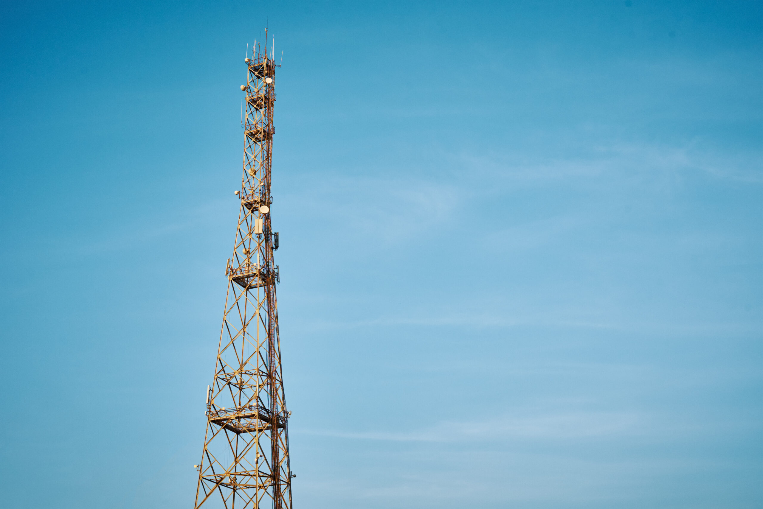 Communication tower with antennas against blue sky